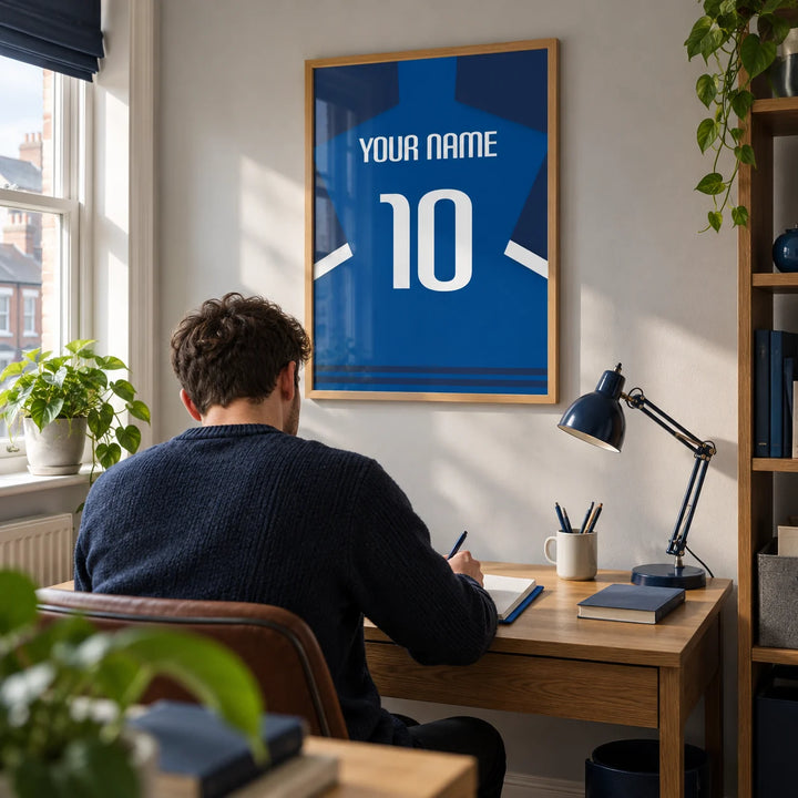 Football Shirt Poster in Blue with Dark Sleeves and White Stripe, framed on the wall of a young adult football fan's home study in a UK terraced house