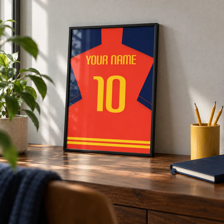 Football Shirt Poster in Red with Navy Sleeves and Yellow Number, a small A4 framed print leaning on a walnut desk