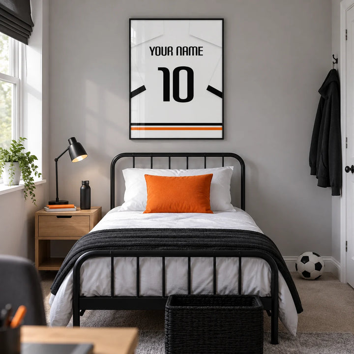 Football Shirt Poster in White with Black Sleeve Bands, framed on the wall of a modern teenage football fan's bedroom (13-17) in a UK family home with a pale grey wall