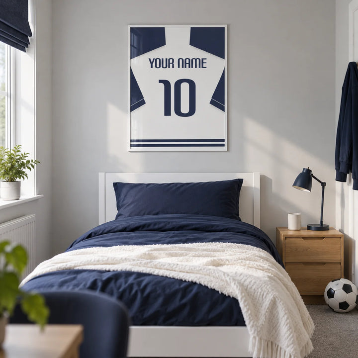 Football Shirt Poster in White with Navy Sleeves and Navy Number, framed on the wall of a modern football-loving teenager's single bedroom (13-17) in a UK family home with a pale grey wall