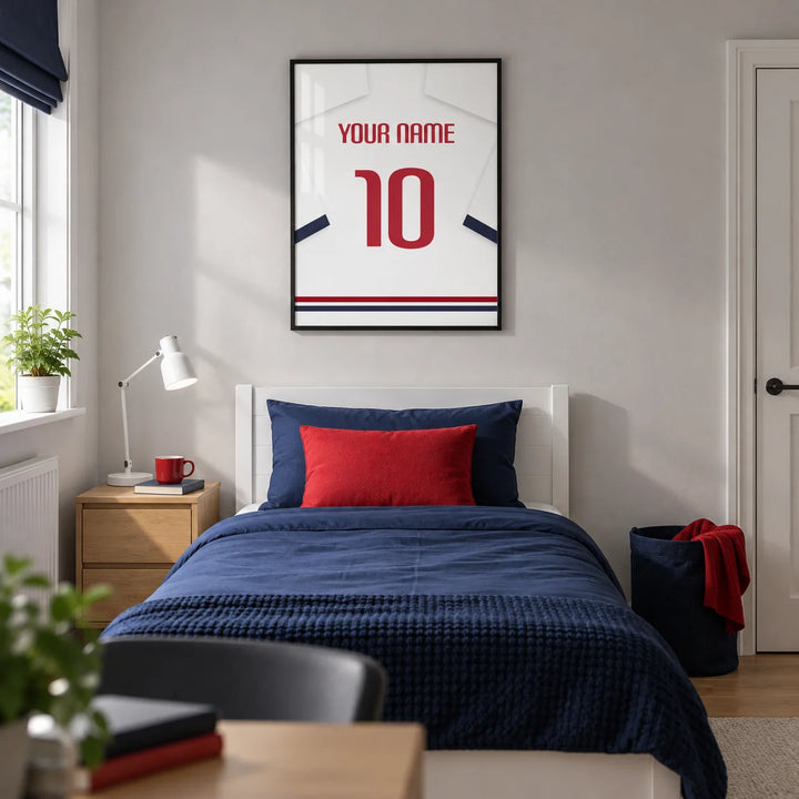 Football Shirt Poster in White with Navy Sleeves and Red Number, framed on the wall of a modern football-loving teenager's single bedroom (13-17) in a UK family home with a pale grey wall and oak floor
