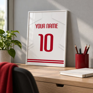 Football Shirt Poster in White with Red Number, a small A4 framed print leaning on a pale oak desk