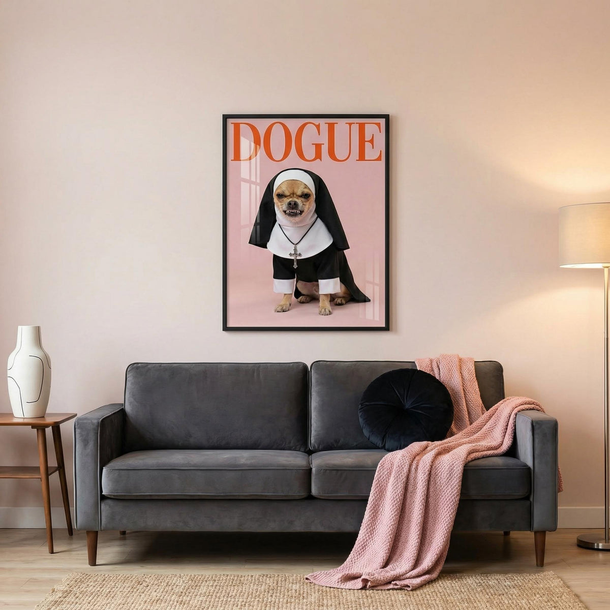Living room with a gray sofa, pink blanket, and a framed picture of a dog in a nun outfit on the wall.