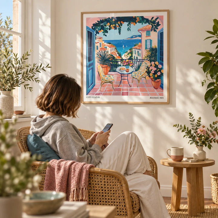 French Coastal Wall Art, framed on the wall of a sunny reading corner by a window with a warm white wall in a living room