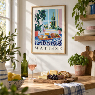 French Prints, framed on the wall of a farmhouse kitchen with a white wall and an oak open shelf