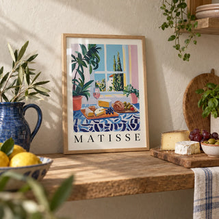 French Prints, a small A4 framed print leaning on an oak kitchen shelf