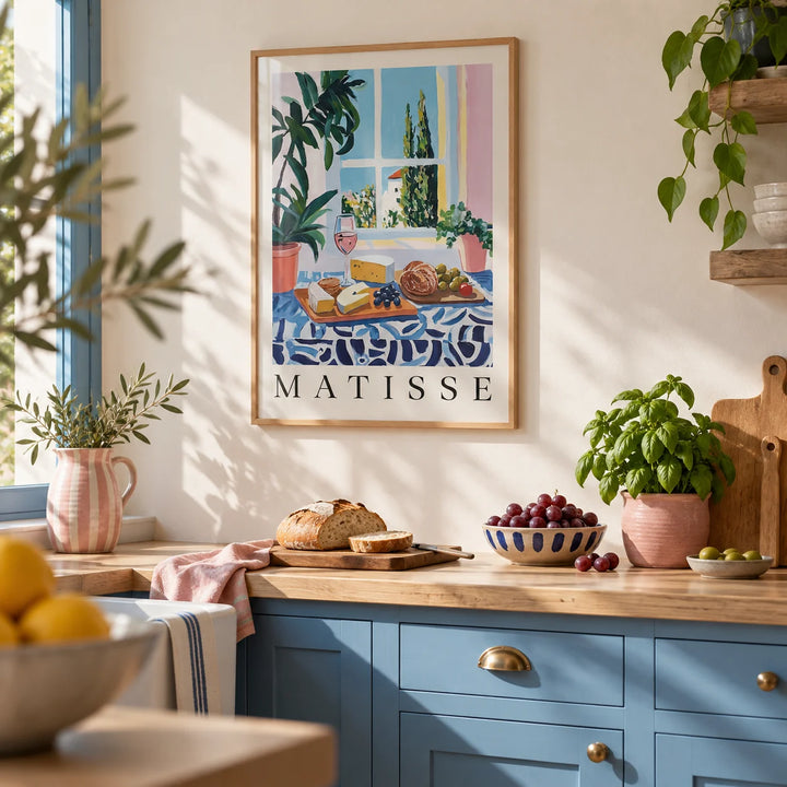 French Prints, framed on the wall of a sunny kitchen with Mediterranean blue painted cabinets and a pale oak worktop