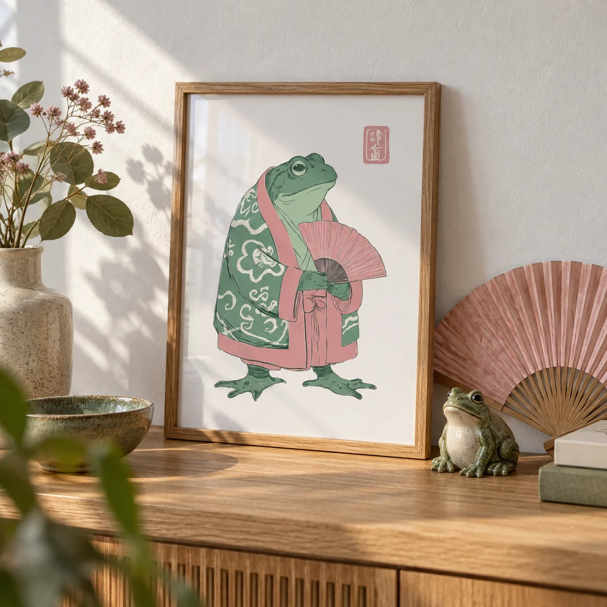 Frog Art Print, a small A4 framed print leaning on an oak shelf in a living room