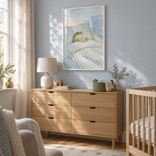 Frog Reading In Bed Print, framed on the wall of a calm nursery in a UK terraced house with a pale blue wall and natural wood furniture