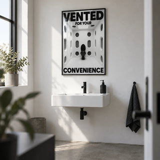 Funny Toilet Sign, framed on the wall of a small creative studio washroom with a plain white wall and a concrete floor