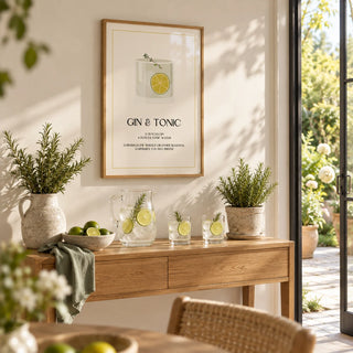 Gin and Tonic Wall Art, framed on the wall of a bright garden room with glass doors and a warm white wall in a hallway