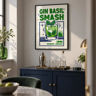 Gin Basil Smash Poster, framed on the wall of a compact home bar alcove in a modern UK apartment with a pale grey wall and a navy painted bar cabinet in a living room