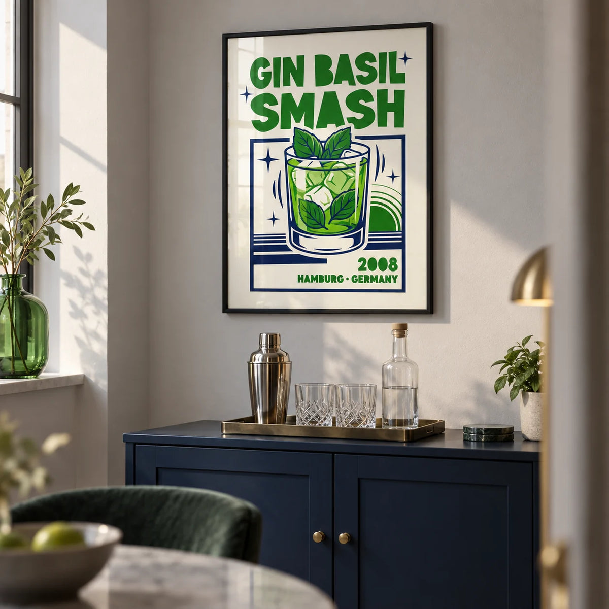 Gin Basil Smash Poster, framed on the wall of a compact home bar alcove in a modern UK apartment with a pale grey wall and a navy painted bar cabinet in a living room