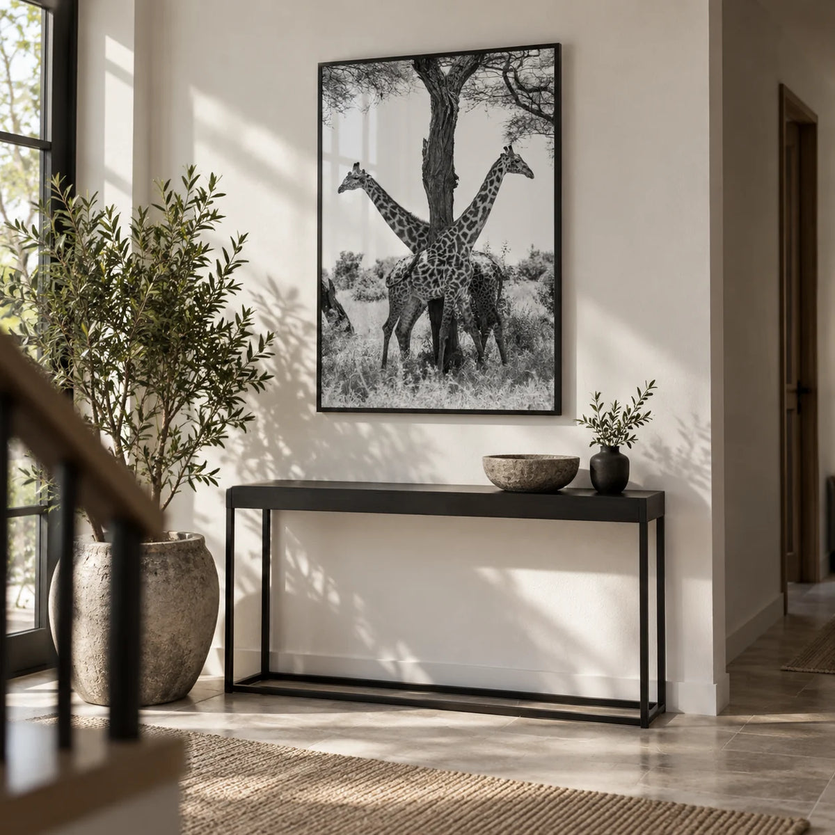 Giraffe Black And White Art Print, framed on the wall of a tall hallway with a white wall