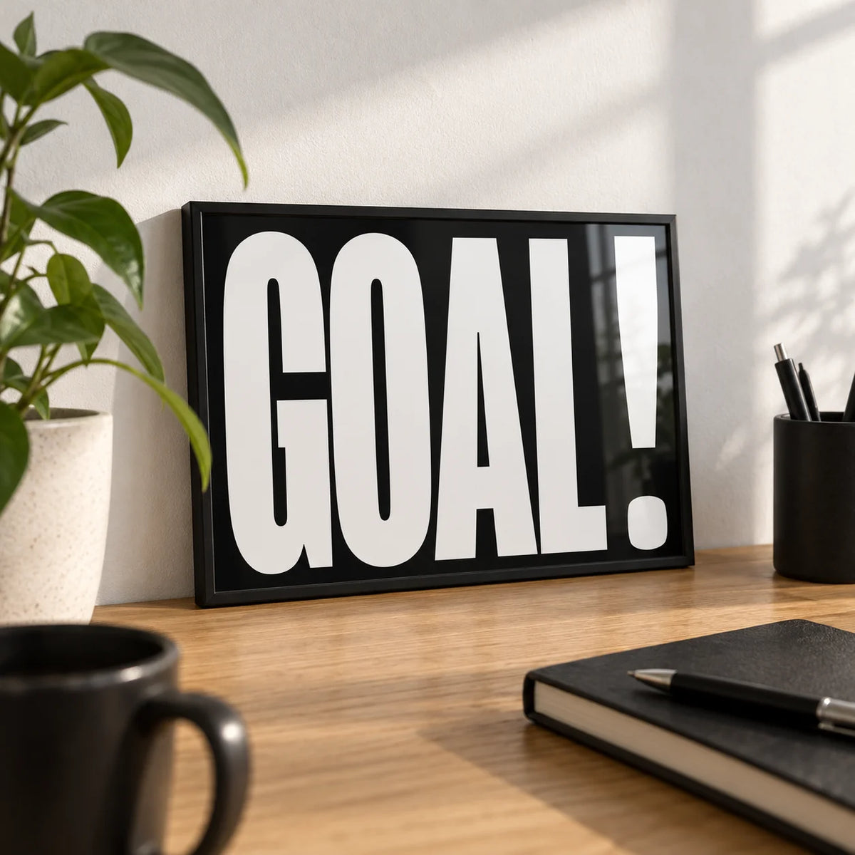 Goal Poster, a small A4 framed print leaning on an oak desk