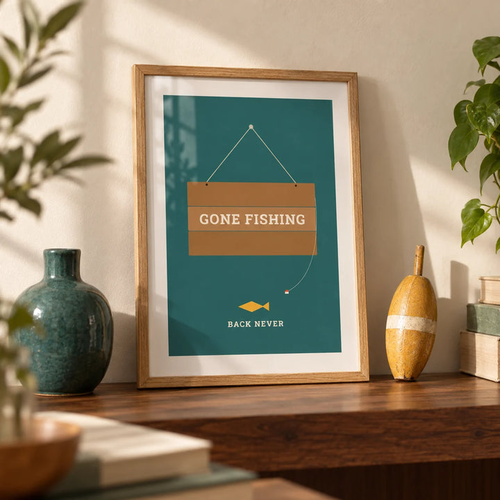 Gone Fishing Poster, a small A4 framed print leaning on a walnut shelf in a living room