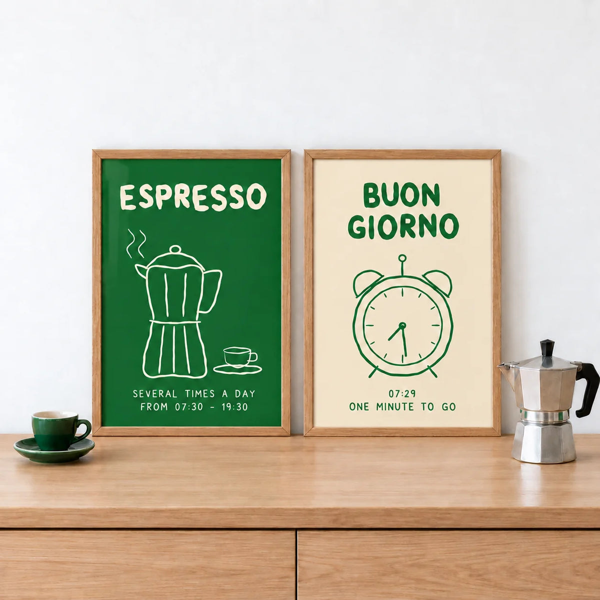Green Kitchen Prints Set of 2 as a small pair leaning on an oak counter: Espresso Hours and Morning Bells shown framed side by side (frames not included)