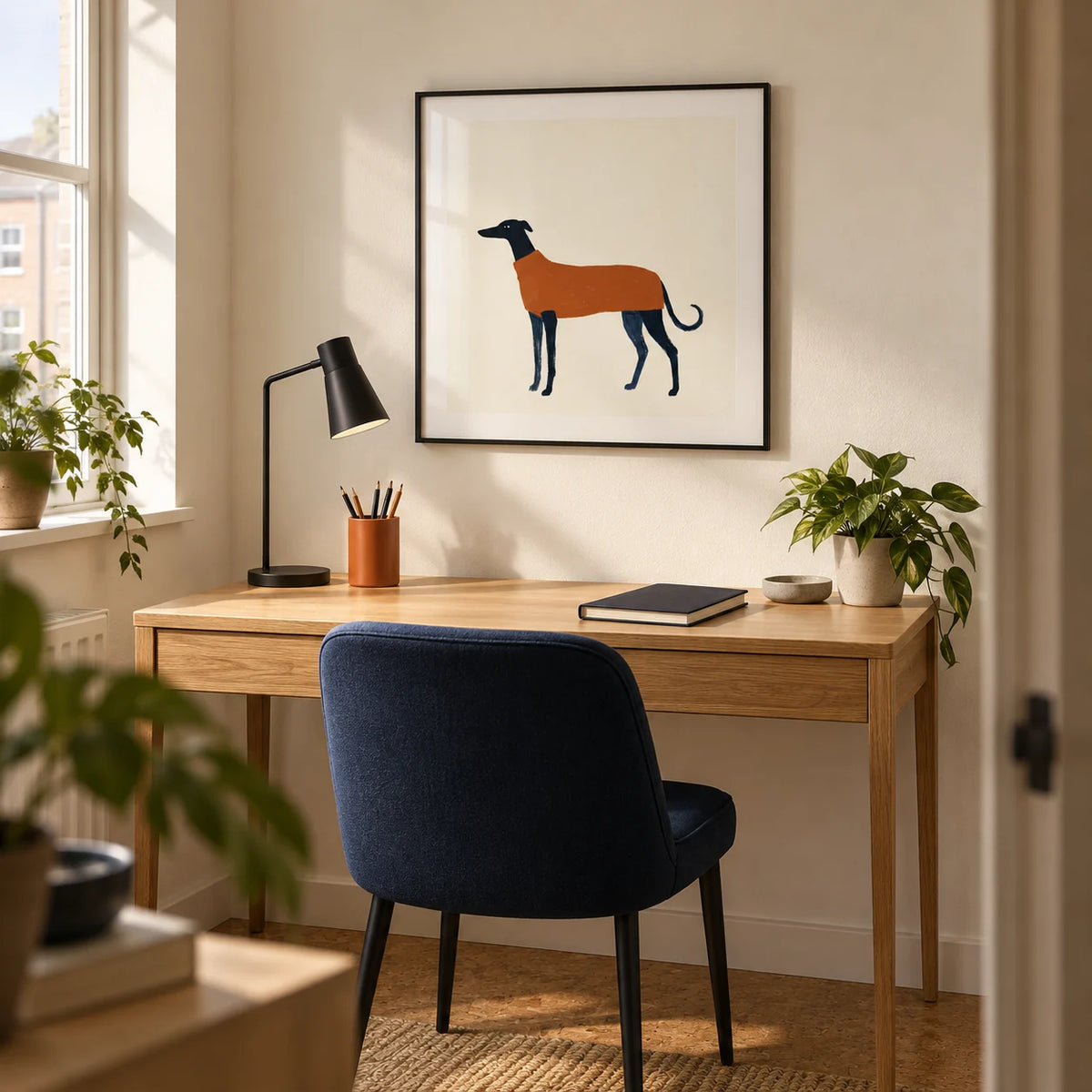 Greyhound Art Print, framed on the wall of a compact home study in a modern UK flat with a warm white wall and cork flooring