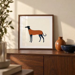 Greyhound Art Print, a small A4 framed print leaning on a walnut sideboard in a living room