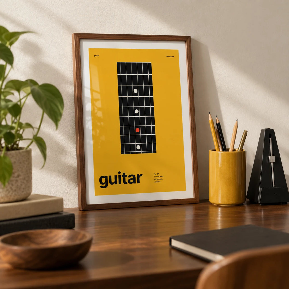 Guitar Poster, a small A4 framed print leaning on a walnut desk