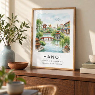 Hanoi Landscape Wall Art, a small A4 framed print leaning on a walnut sideboard in a living room