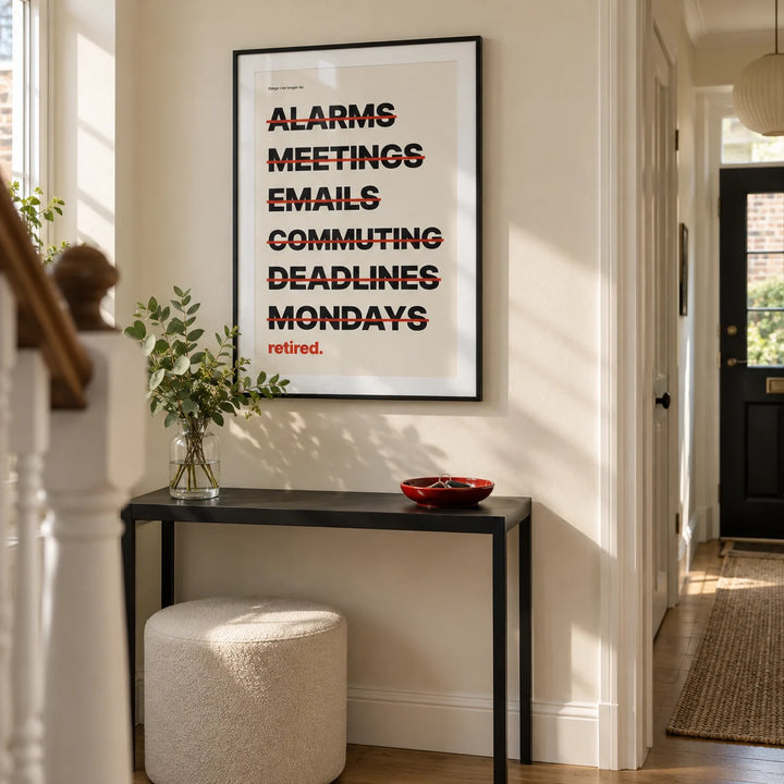 Happy Retirement Poster, framed on the wall of a crisp hallway in a renovated UK terraced house with a pale cream wall and natural oak floor