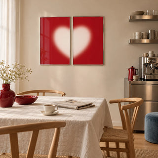 Heart wall art set of 2 hung above a dining table in a warm kitchen