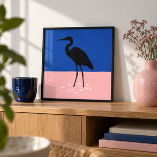 Heron Art Print, a small A4 framed print leaning on an oak shelf in a living room