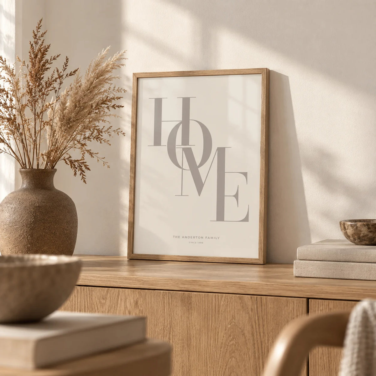 Home Beige Personal Print, a small A4 framed print leaning on an oak sideboard in a living room