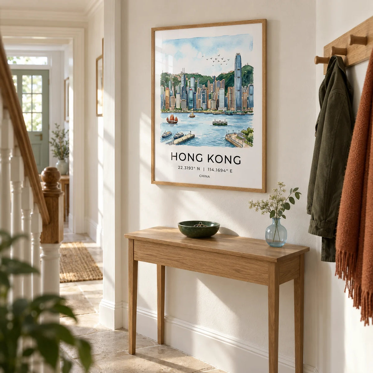 Hong Kong Skyline Art Print, framed on the wall of a bright hallway in a UK terraced home with warm white plaster walls and pale stone flooring