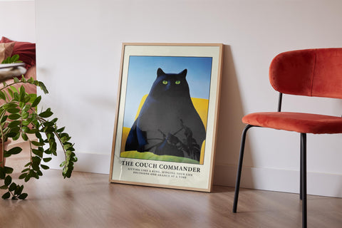 Fat black cat with green eyes sitting on a couch poster.