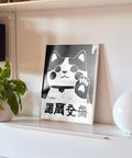 Bold black-and-white beckoning cat wall art for luck.