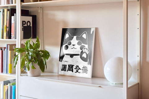 Bold black-and-white beckoning cat wall art for luck.