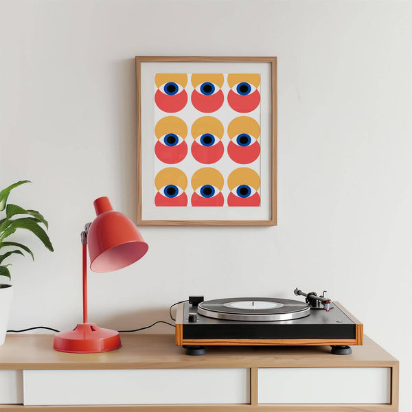 Framed wall art eye artwork displayed above a mid-century sofa