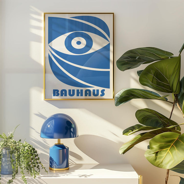 Bauhaus framed print of a stylised blue eye with typographic text beside a blue lamp and plant