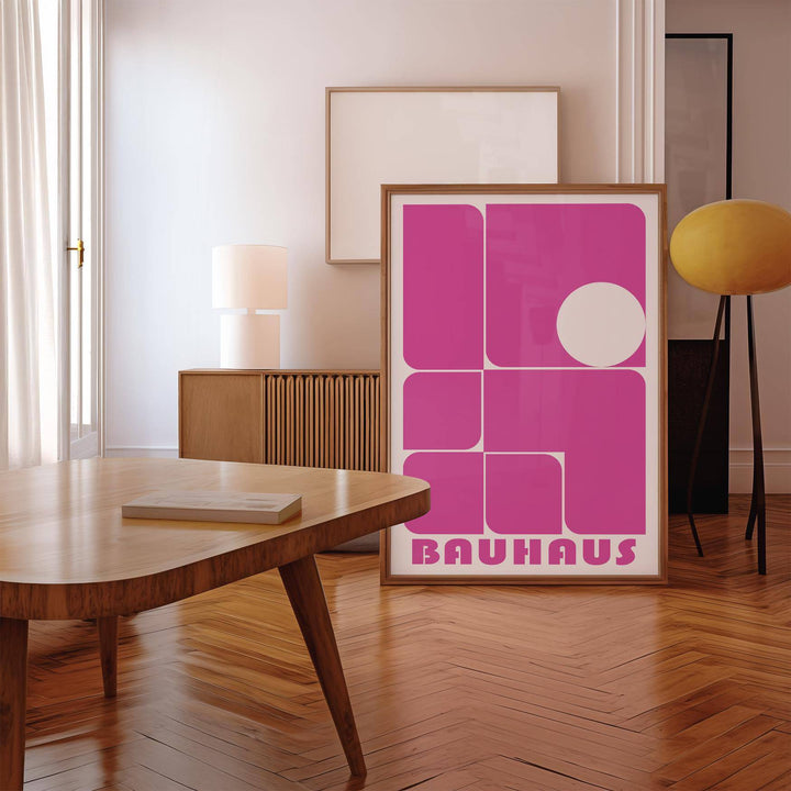 Wall Art Pink print leaning on a wooden floor with a yellow lamp nearby in a modern room