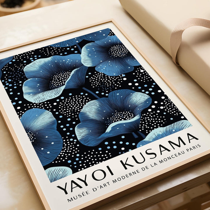 Framed close-up of wall art blue flowers with dark background and white text on beige surface