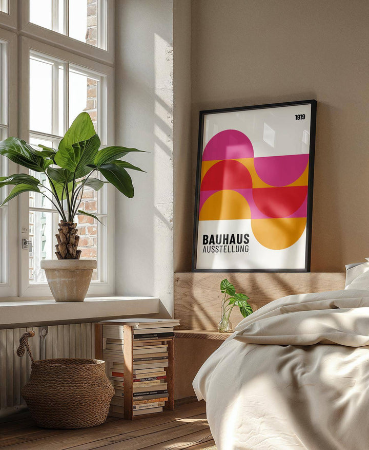 Large artwork for walls with semi-circles in pink red and orange leaning on a wooden headboard in a bedroom