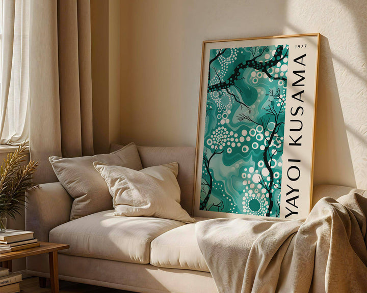 Teal wall decor leaning on a sofa in soft natural light with beige cushions and curtains