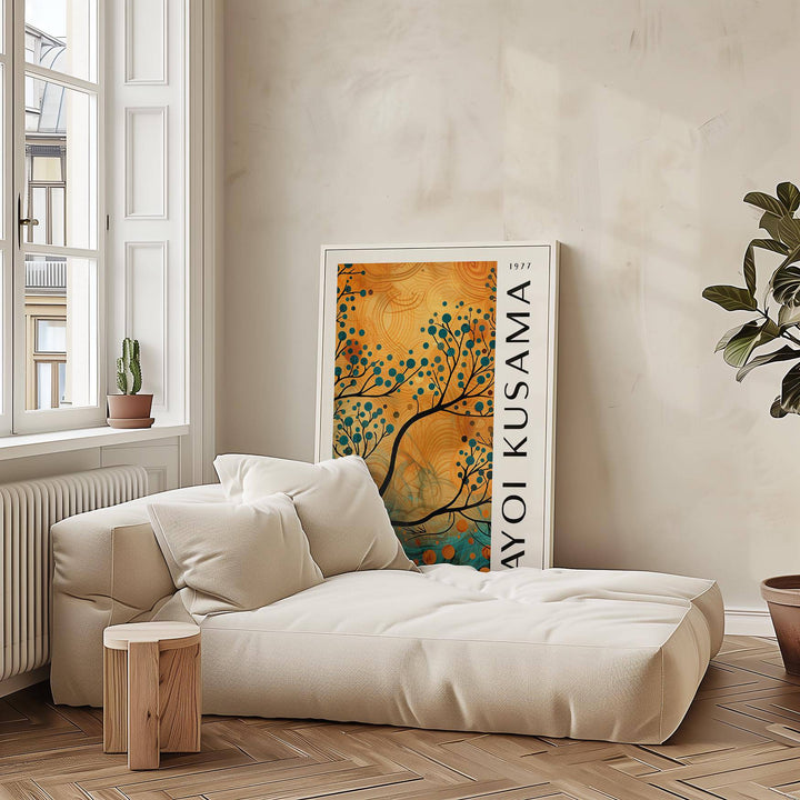 Print leaning on the floor showing an abstract tree branch with orange and teal colours by a beige sofa