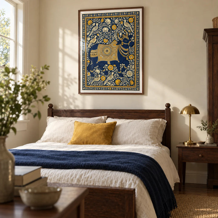 Indian Art Print, framed on the wall of a restful bedroom in a characterful UK home with warm cream walls and dark wooden furniture