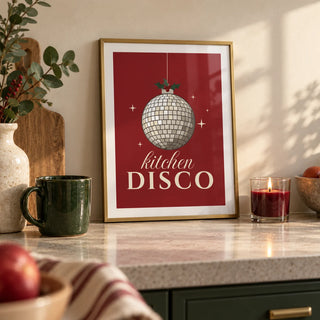 Kitchen Disco Print, a small A4 framed print leaning on a pale stone kitchen worktop