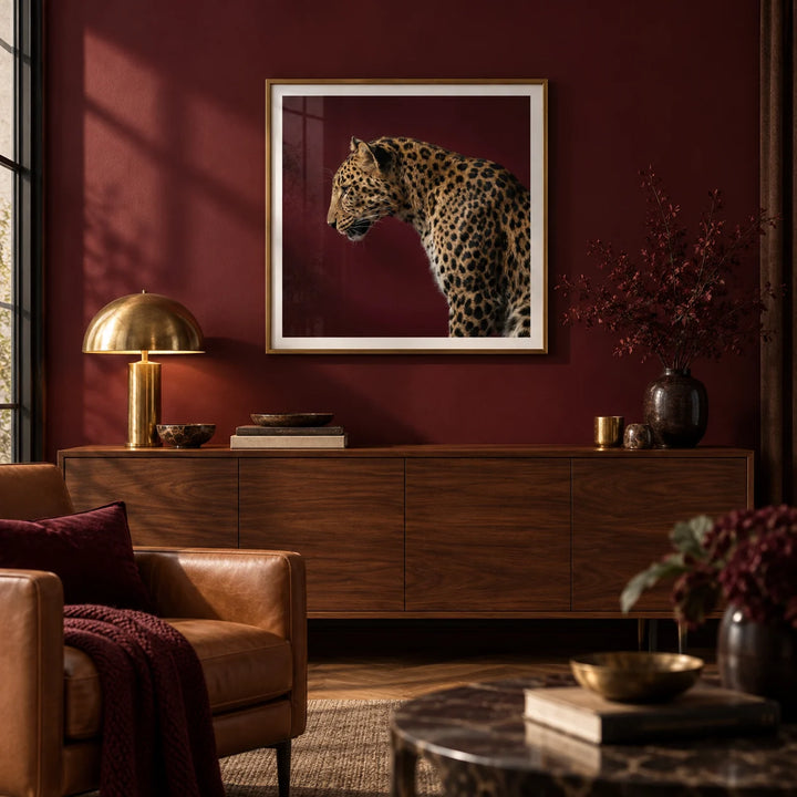Leopard Art Print, framed on the wall of a moody luxe living room with a deep burgundy painted wall