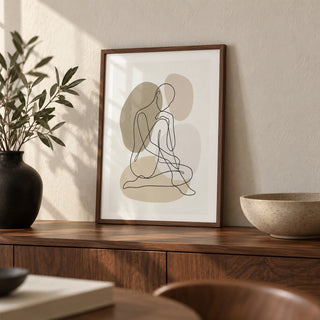 Line Art Figure Print, a small A4 framed print leaning on a walnut sideboard in a living room