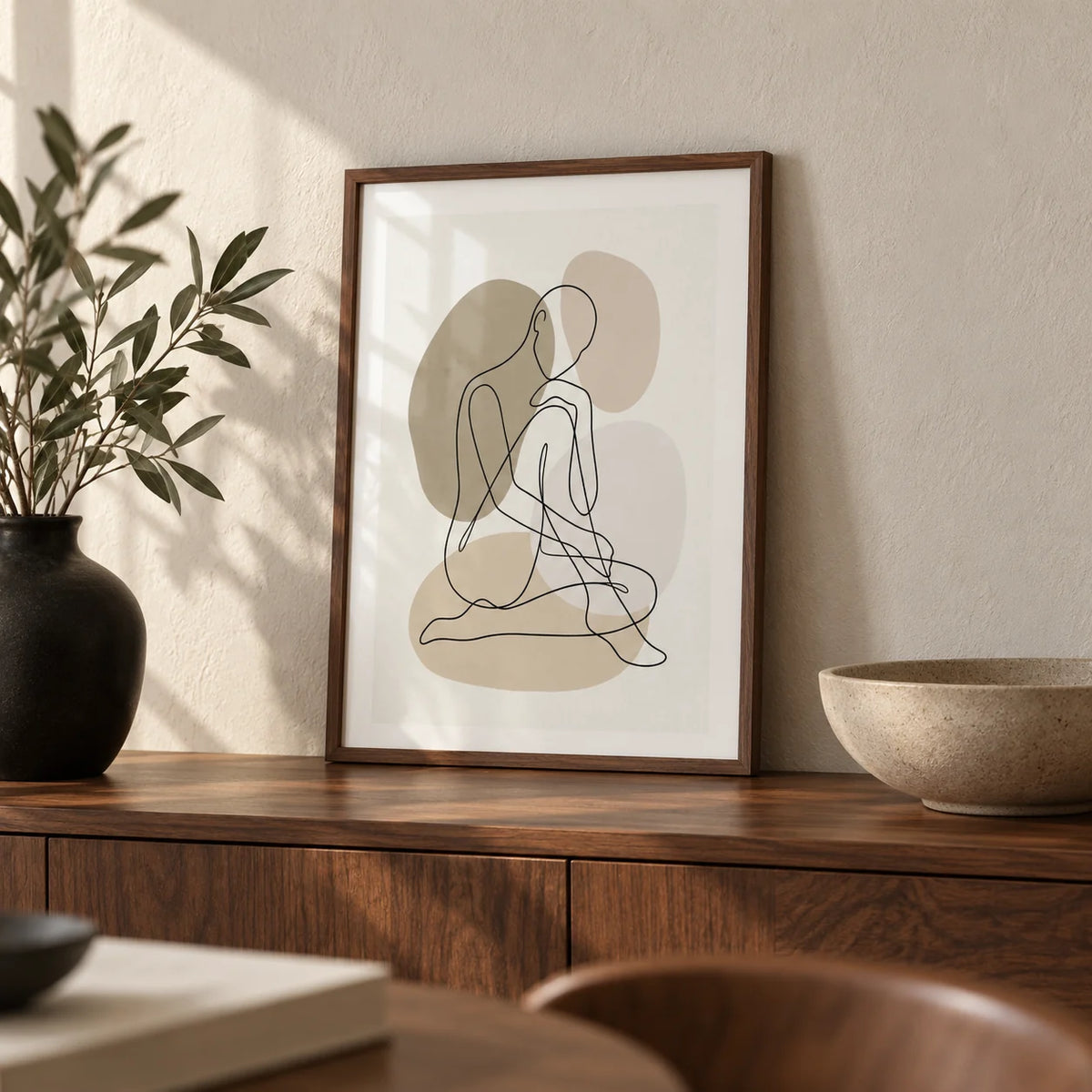 Line Art Figure Print, a small A4 framed print leaning on a walnut sideboard in a living room