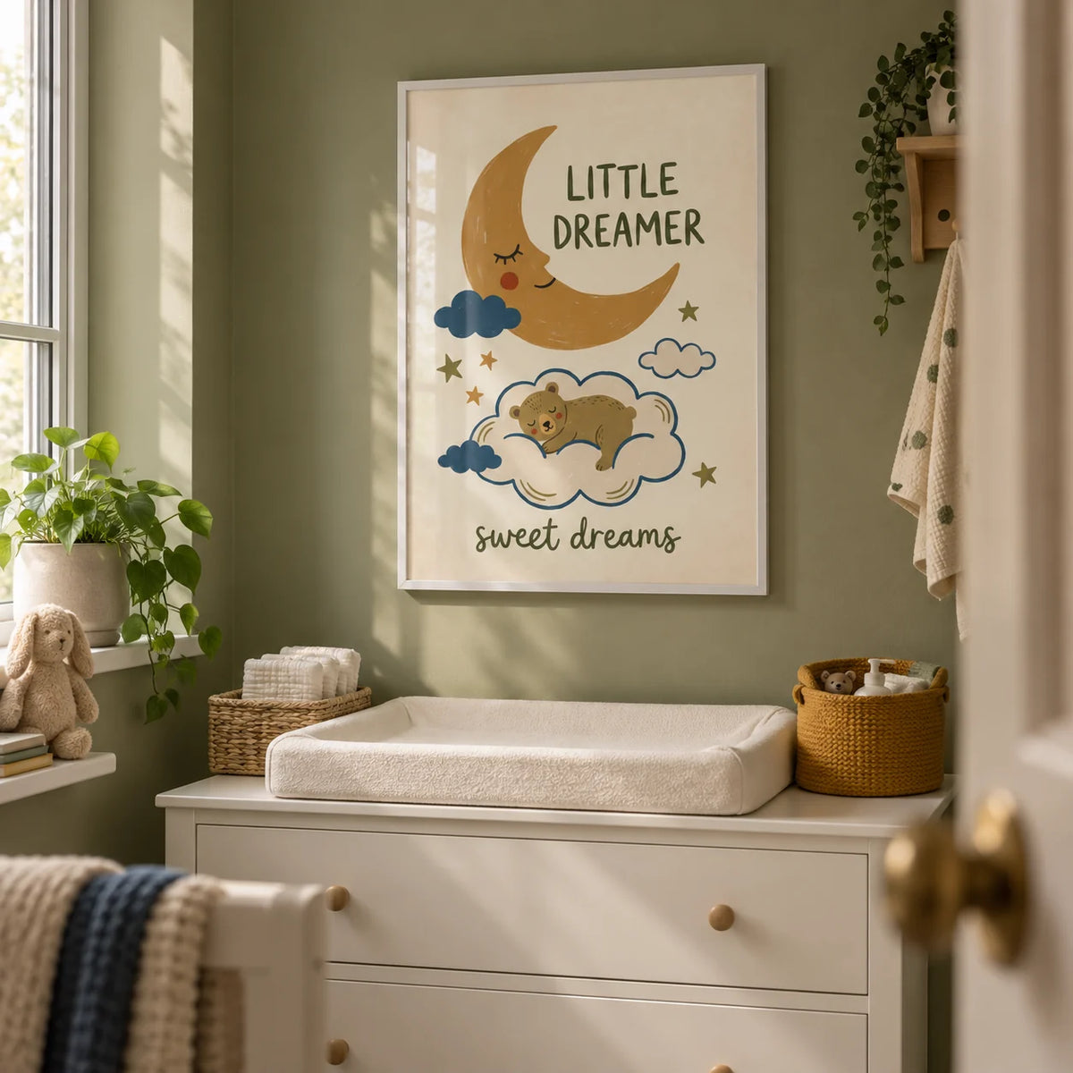 Little Dreamer Wall Art, framed on the wall of a compact nursery changing alcove in a British flat with muted olive green walls