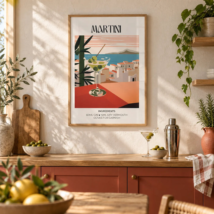 Martini Poster, framed on the wall of a sunny Mediterranean-style kitchen with a warm white plaster wall and plain terracotta red cabinets