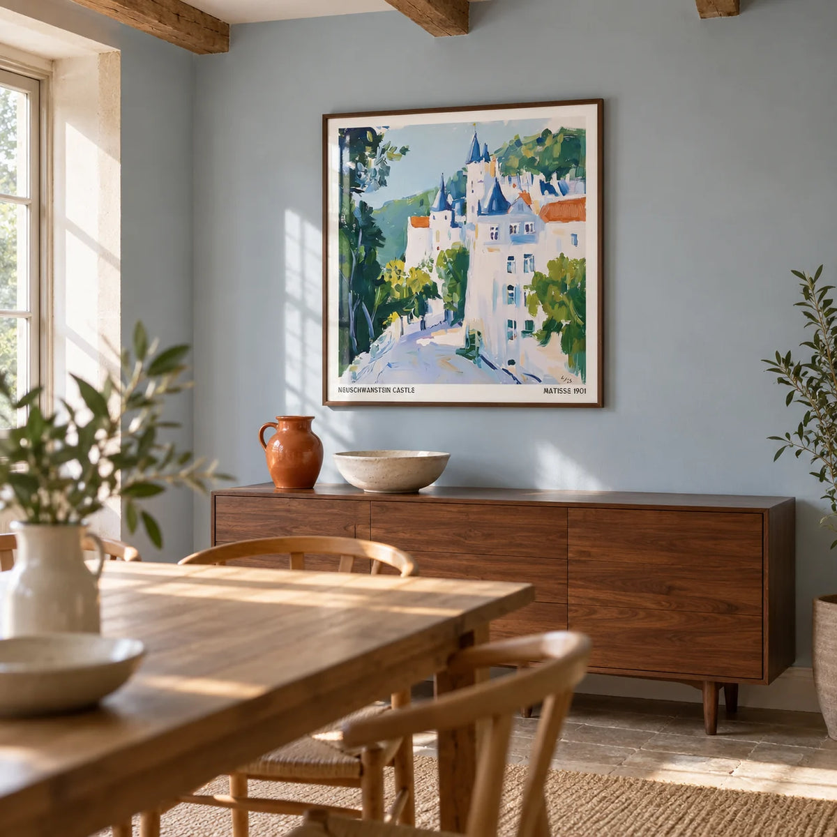 Medieval Castle Art, framed on the wall of a relaxed dining room in a British cottage renovation with pale blue painted walls and exposed oak ceiling beams
