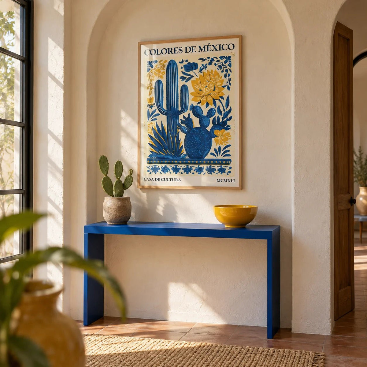 Mexican Folk Art, framed on the wall of a Mexican-modern hallway with an arched plaster niche