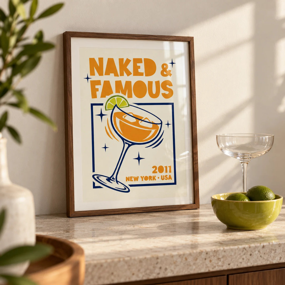 Mezcal Cocktail Art Print, a small A4 framed print leaning on a pale stone home-bar worktop in a kitchen